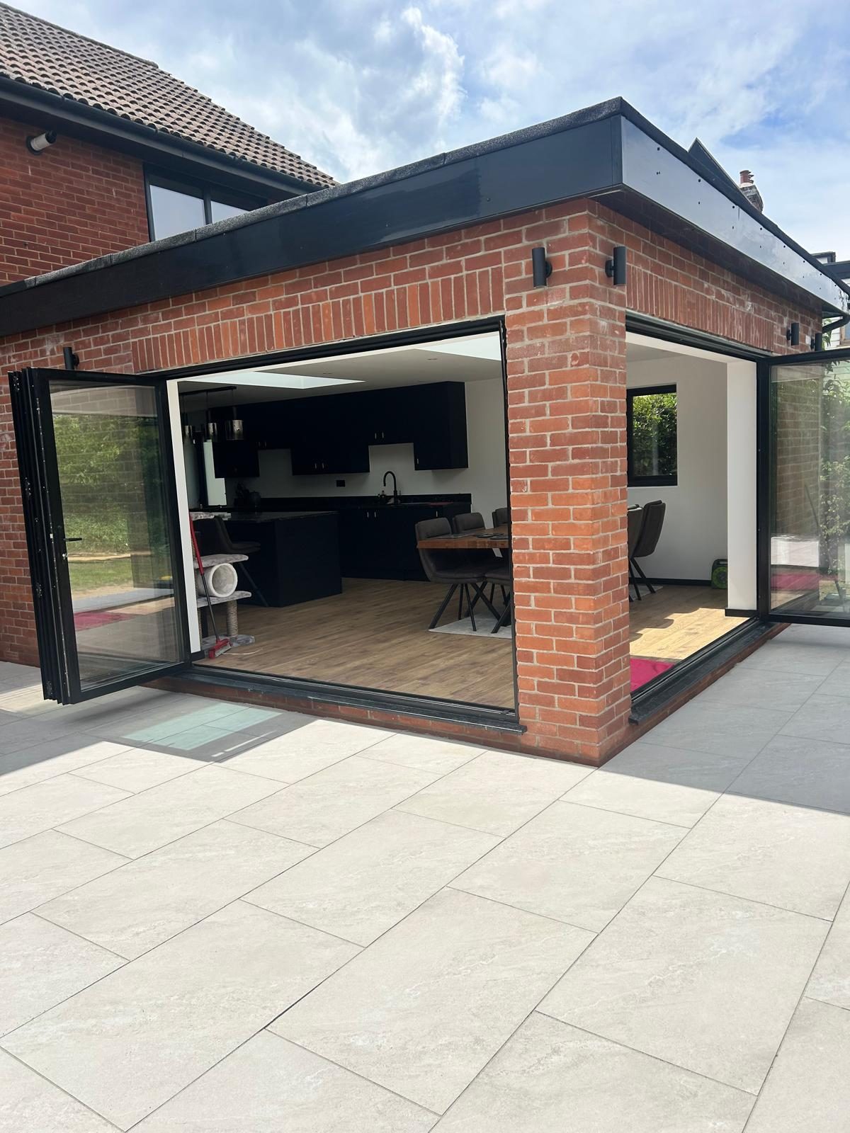 Corner bi-fold doors open at the rear of the house