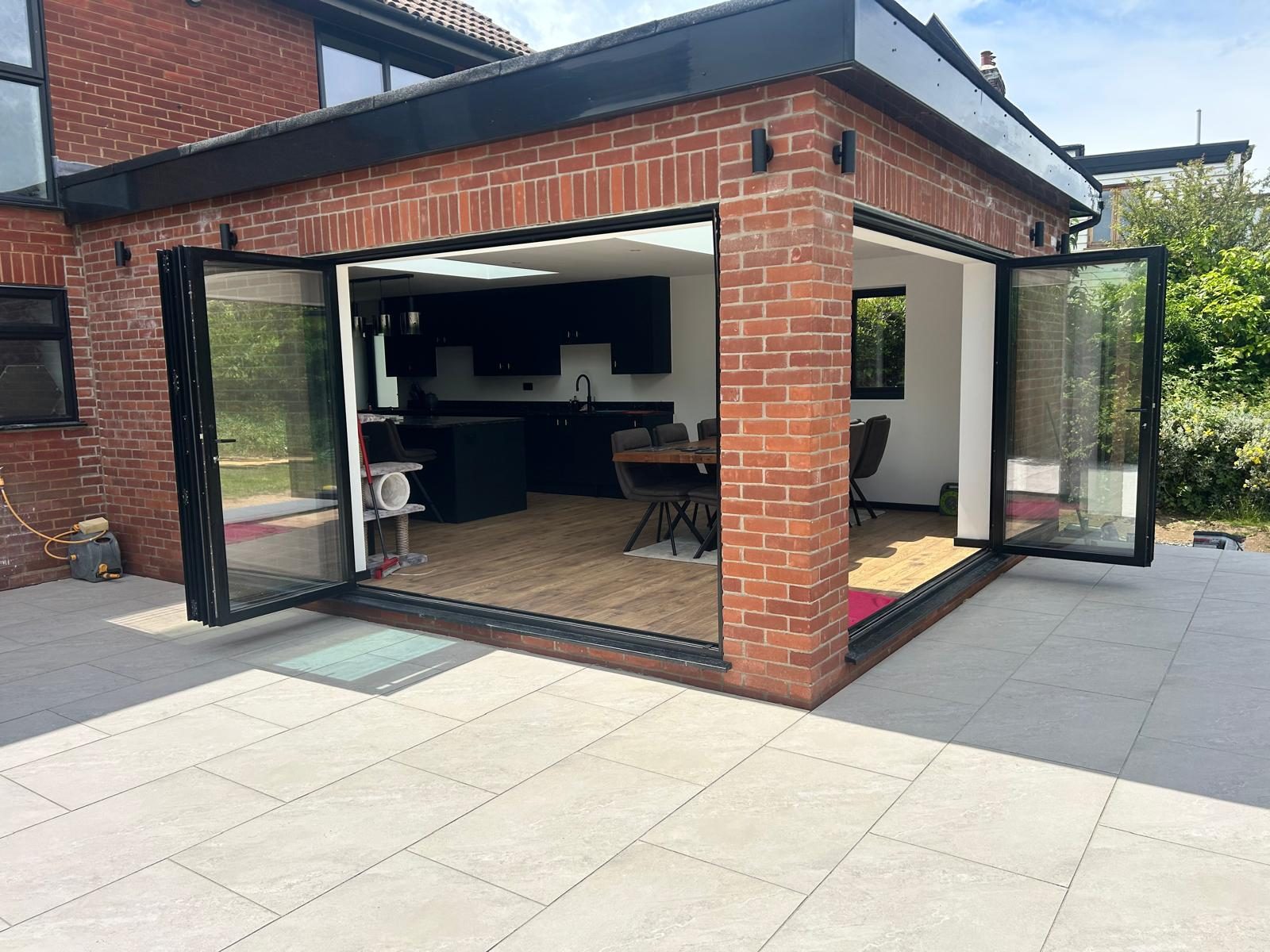 Corner bi-fold doors folded back onto the porcelain terrace of a family home in Felixstowe
