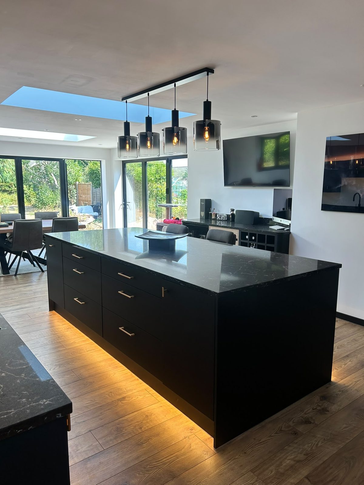 Open plan kitchen and dining space with roof lights and bi-fold doors