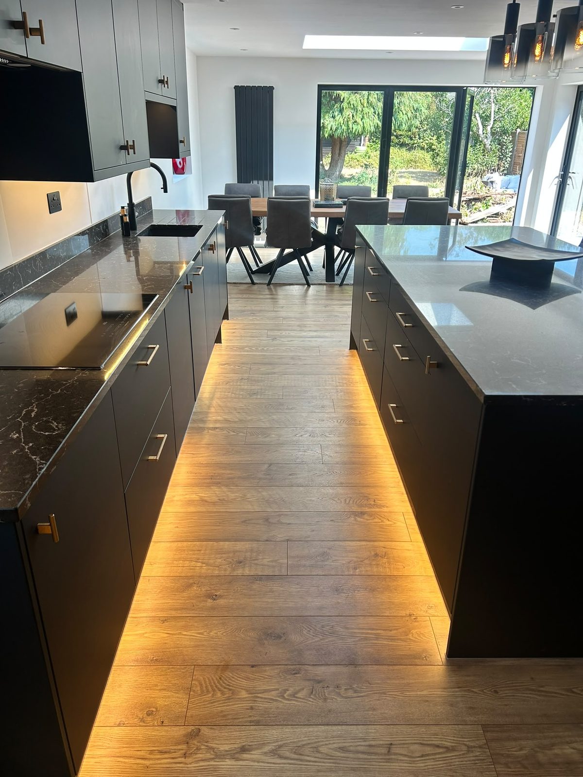 Full run of matte black kitchen units with plinth lighting