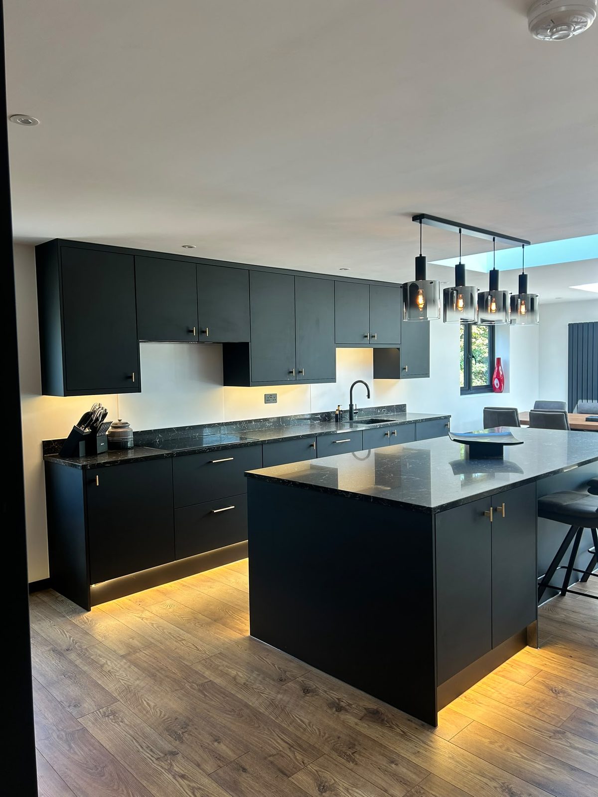 Wide view of the black kitchen and island under the roof light