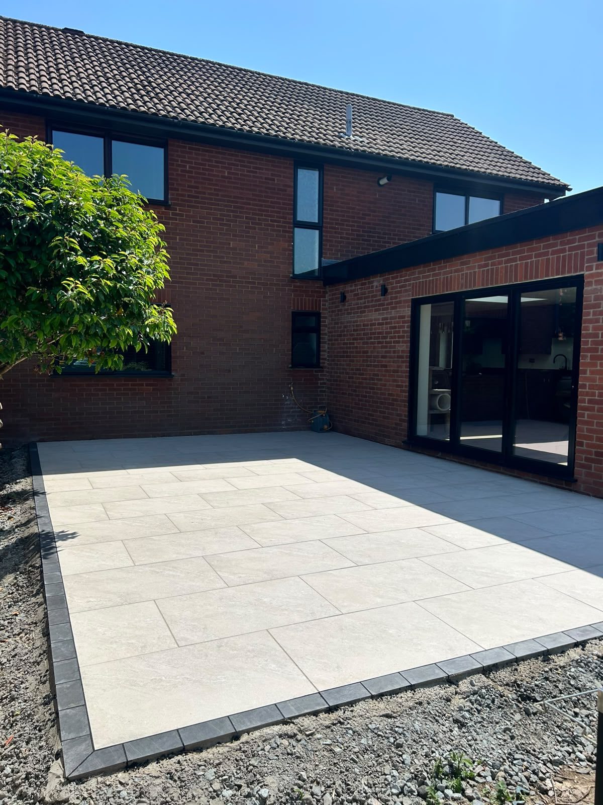 Large format porcelain patio with dark contrasting border