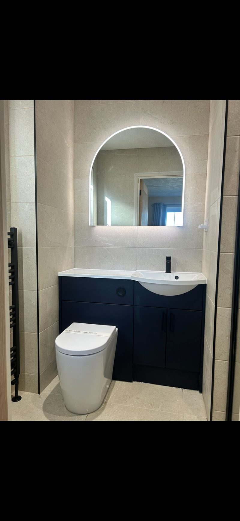 Navy vanity with arch LED mirror